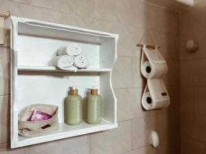 a bathroom with two green bottles of soap and towels at Casa Arrayanes Tempo in Esquel +20 photos