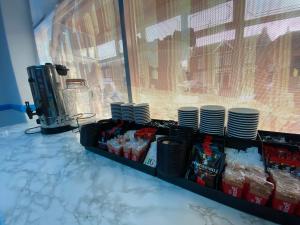 a counter with plates and cups on top at The New Athena Hotel in Blackpool