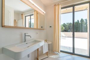 a bathroom with a sink and a large window at Casale Valverde in Alghero