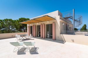 a house with two chairs and a patio at Casale Valverde in Alghero