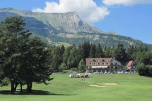 a golf course with a resort and a mountain at Chalet Coste Belle in La Fare-en-Champsaur