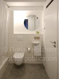 uma casa de banho com um WC, um lavatório e um espelho. em Studio Heinrich 1 em Tutzing