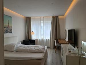 Habitación de hotel con cama y escritorio en Soleil Rooms - Pure Living in the City Center en Hannover