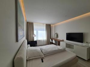 um quarto de hotel com uma cama e uma televisão de ecrã plano em Soleil Rooms - Pure Living in the City Center em Hanôver