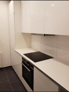 cocina con armarios blancos y fogones negros en Soleil Rooms - Pure Living in the City Center, en Hannover