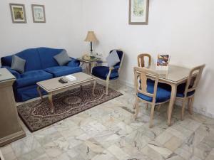 uma sala de estar com um sofá azul e uma mesa em روتانة للشقق المخدومة بالحمرا em Jeddah