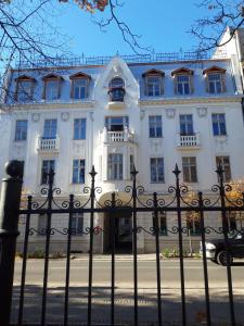 a white building with a fence in front of it at Hampton Court Apartment in Łódź