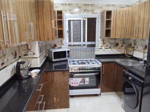 una cucina con piano cottura e forno a microonde di cozy and modern apartment in central location in Cairo Mohandessin near Nile a Il Cairo