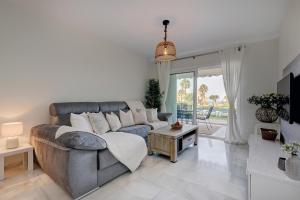 un soggiorno con divano e tavolo di La Cala gorgeous 2 bedroom apartment with stunning gardens, pools and sea views a Mijas Costa