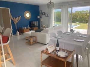 - un salon avec une table et un canapé dans l'établissement La maison aux palmiers, à Arpaillargues-et-Aureillac