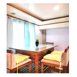 a dining room with a glass table and two chairs at Fely's transient house in Puerto Princesa City
