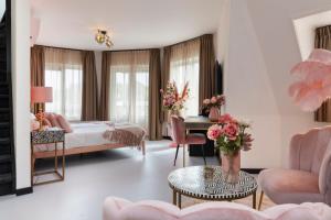 a bedroom with a bed and a table in a room at Dormio Wijnhotel Valkenburg in Valkenburg
