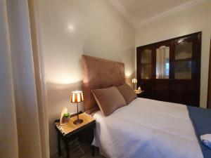um quarto com uma cama e uma mesa de cabeceira com um candeeiro em Nice 2 BR flat - L'Appart'215- Agadir em Agadir
