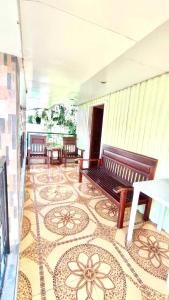 Habitación con bancos y suelo de baldosa. en Fely's transient house en Puerto Princesa
