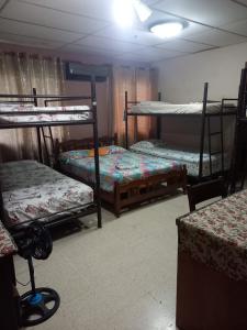 Pokój z 3 łóżkami piętrowymi i stołem w obiekcie PaCasa Hostel w mieście David