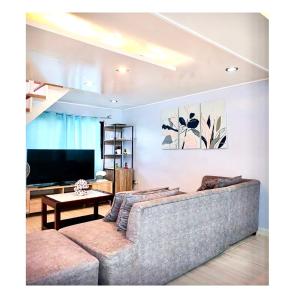 sala de estar con sofá y TV en Fely's transient house en Puerto Princesa