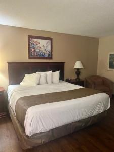 a bedroom with a large bed in a hotel room at Baymont by Wyndham Battle Creek/I-94 in Battle Creek