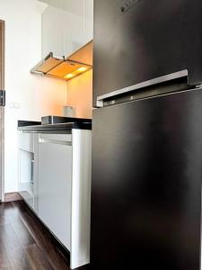 a kitchen with a black refrigerator in a room at HMJ2 Entire Apt on 34th floor in Khonkaen city center in Ban Si Than