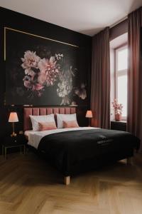 um quarto com uma cama grande e uma pintura na parede em Apartament 10 by Hidden Garden em Lódź