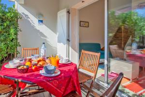 Residence Agula Mora في Lecci: طاولة مع قماش الطاولة الحمراء مع الطعام عليها