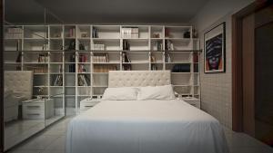 - une chambre avec un grand lit blanc et des étagères dans l'établissement Utopia Bed & Breakfast, à Marigliano