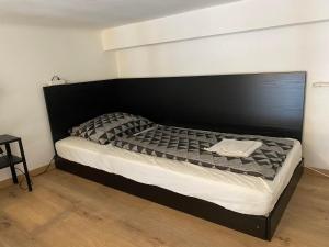 a bed with a black headboard in a room at SparrOwl Apartments in Budapest