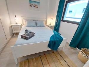 een slaapkamer met een wit bed en blauwe gordijnen bij Blue Velvet by Sea You There Fuerteventura in Corralejo