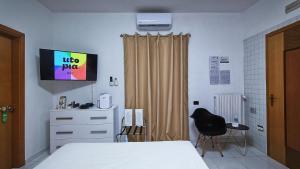 - une chambre avec un lit et une télévision murale dans l'établissement Utopia Bed & Breakfast, à Marigliano