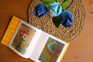 een boek naast een mand met bloemen en een plant bij Blue Velvet by Sea You There Fuerteventura in Corralejo