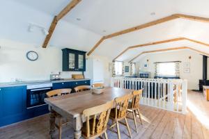 a kitchen and dining room with a wooden table and chairs at The Barn, St Minver in Wadebridge