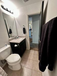 La salle de bains est pourvue de toilettes, d'un lavabo et d'un miroir. dans l'établissement Sweet Oasis, à Edmond
