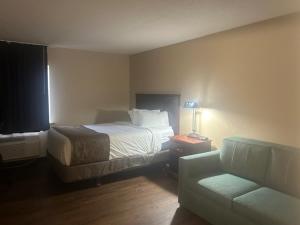 a hotel room with a bed and a couch at Baymont by Wyndham Battle Creek/I-94 in Battle Creek