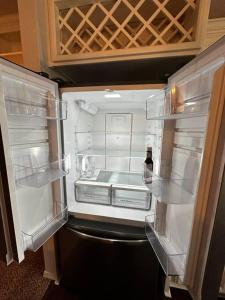 an open refrigerator with a bottle of wine in it at Sweet Oasis in Edmond