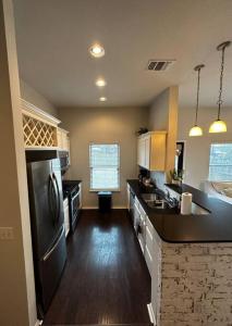 a kitchen with a stainless steel refrigerator and wooden floors at Sweet Oasis in Edmond