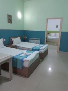 a bedroom with two beds and a mirror in it at Lind Guest House B&B in Gyumri