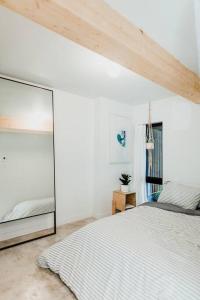 a bedroom with a bed and a large mirror at Le Duplex St-Sauveur, Maison entière in Quebec City