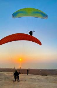 a person is flying a parachute with a helicopter at Titanic House by ahmed in Mirleft