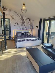 a bedroom with a large bed and a couch at Studio avec terrasse in Brest