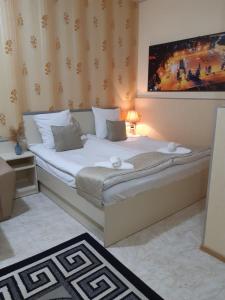 a bedroom with a large bed with white sheets at Lind Guest House B&B in Gyumri
