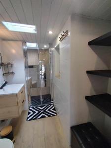baño con ducha y alfombra blanca y negra en Studio avec terrasse en Brest