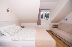 een slaapkamer met een wit bed en een bank bij Apartamenty Gościnne 54 Szklarska Poręba in Szklarska Poręba