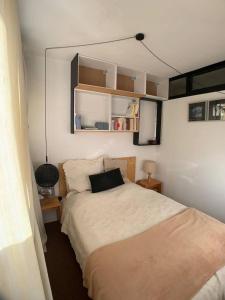 1 dormitorio pequeño con 1 cama y TV en APPARTEMENT avec VUE MONTAGNE en Le Sauze