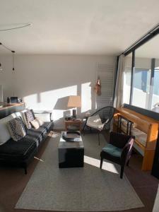 sala de estar con sofá, sillas y piano en APPARTEMENT avec VUE MONTAGNE en Le Sauze
