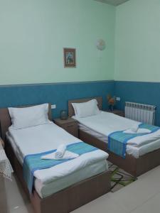 2 letti posti uno accanto all'altro in una stanza di Lind Hotel and Guest House a Gyumri