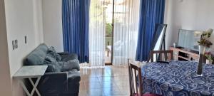 a living room with blue curtains and a couch at Borde Mar Costa Papudo in Papudo