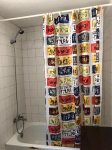 cortina de ducha con muchas latas de refresco en el baño en Casa Bosquemar, en Concón