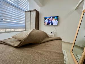 a bedroom with a bed and a tv on the wall at Blue Sea Studio 1 minute away from Luanda Bay in Luanda