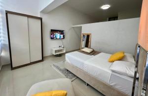 a bedroom with a large bed with a yellow pillow at Blue Sea Studio 1 minute away from Luanda Bay in Luanda