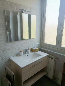 bagno con lavandino bianco e specchio di Tommy Guest House Roma a Roma