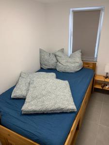 Una cama con sábanas azules y almohadas. en Ferienstüble im Zabergäu- Ferienwohnung, en Brackenheim